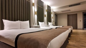 Una habitación de hotel con una cama grande, una mesita de noche, un espejo y una puerta.