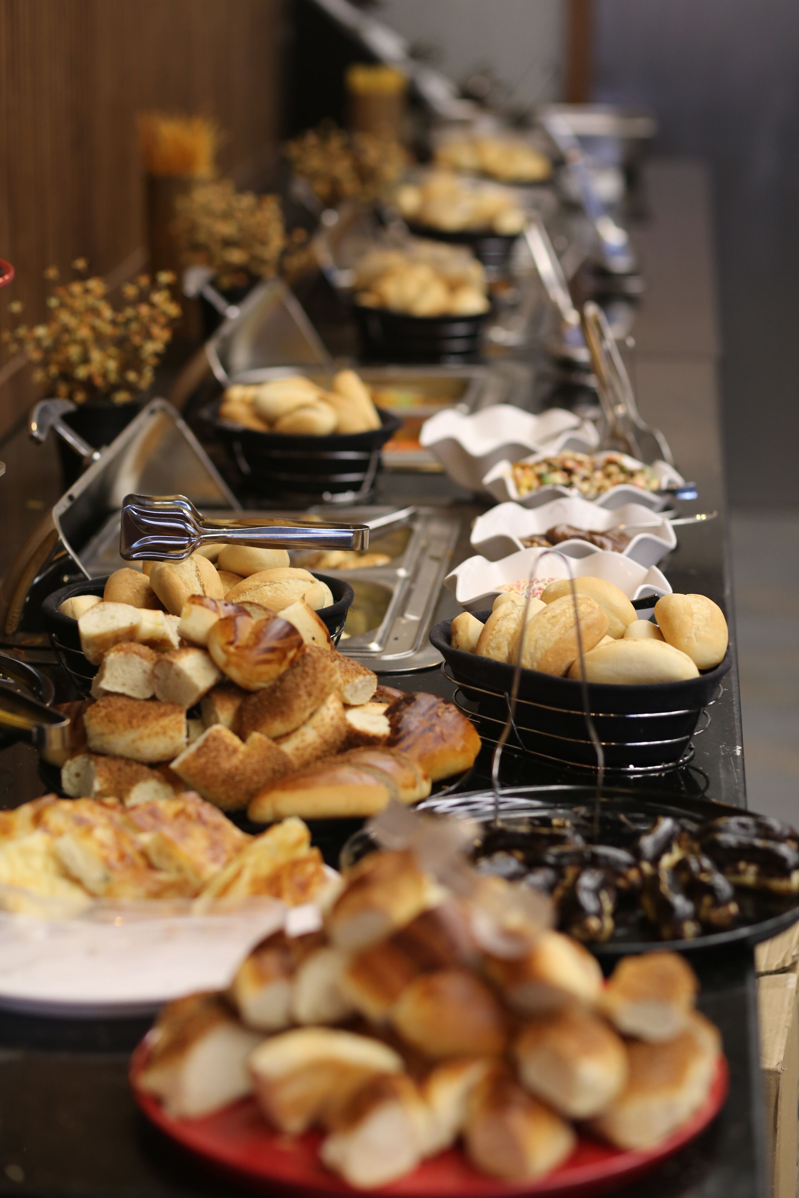 A buffet with various food items including bread, pastries, and other baked goods.