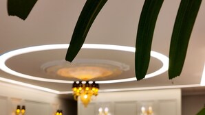 Un interior moderno con suelo estampado, una lámpara central y arreglos de asientos.
