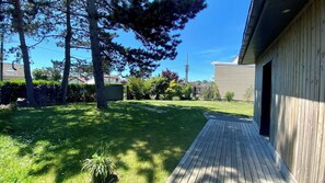 Enjoy an outdoor space surrounded by lush trees and shrubs, with a convenient deck leading to the garage.