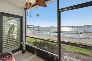 A balcony with a view of a bridge, a pool, and a palm tree. - Breathtaking Panoramic Ocean views and quick drive or walk to Pass A Grill Beach (St. Petersburg)