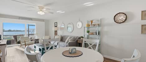 A spacious living area with a dining table, chairs, and a view of the outdoors.