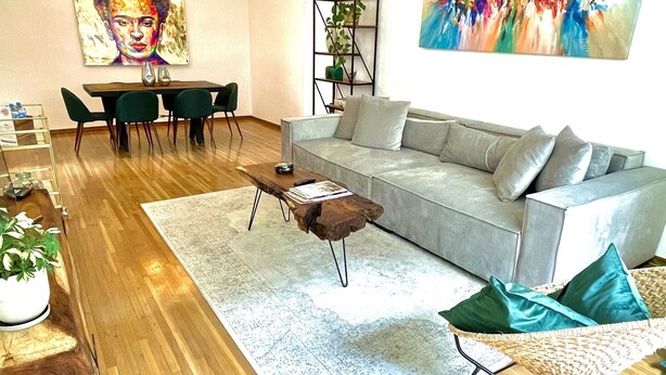 A modern living room with a grey sofa, wooden coffee table, and a dining area with a table and chairs. - Beautiful apartment in downtown Polanco (Ciudad de México)