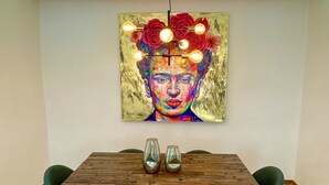 A dining area with a wooden table, two chairs, and a colorful painting above the table. - Beautiful apartment in downtown Polanco (Ciudad de México)