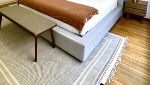 A neatly arranged bedroom with a bed, a bench, a bedside table, and a wall-mounted lamp. - Beautiful apartment in downtown Polanco (Ciudad de México)
