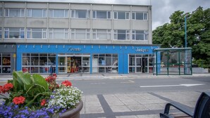 Ein Gebäude mit zwei Schaufenstern, davon eines namens 'Arcade' und das andere 'Taddy's'.