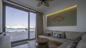 Uma sala de estar moderna com uma grande porta de vidro deslizante que dá para uma varanda com vista para um corpo de água.