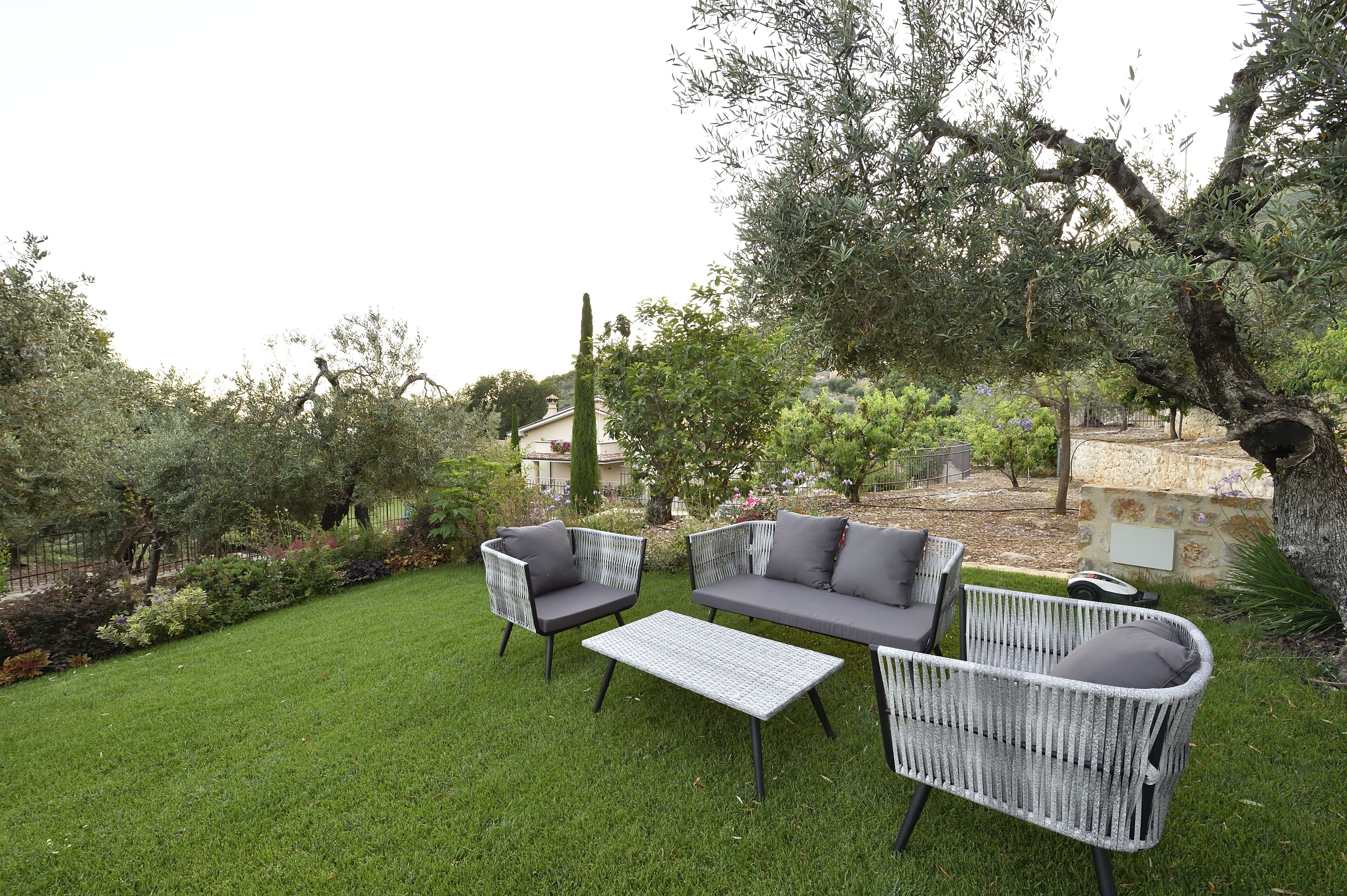 An outdoor seating area with wicker furniture and a stone wall.