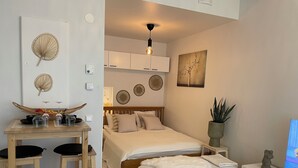 Un dormitorio moderno con cama, mesita de noche y un pequeño rincón de descanso.