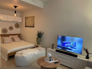 A modern bedroom with a bed, a TV, a small table, and decorative items. - Immaculate 1-bed Apartment in Tampere (Tampere)