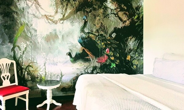 A bedroom with a bed, a chair, and a small table.
