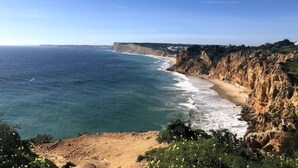 A coastal landscape with cliffs and a beach.
