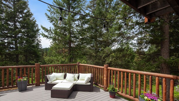 A wooden deck with outdoor furniture and potted plants. - Queen - Queen bedroom with private bathroom, mini fridge (Olney)
