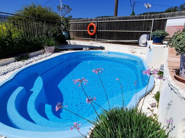 A swimming pool with a wooden fence, a lifebuoy, and a sign. - Lefkas Kavalos Atmospheric Villa Kavalina (Lefkada)