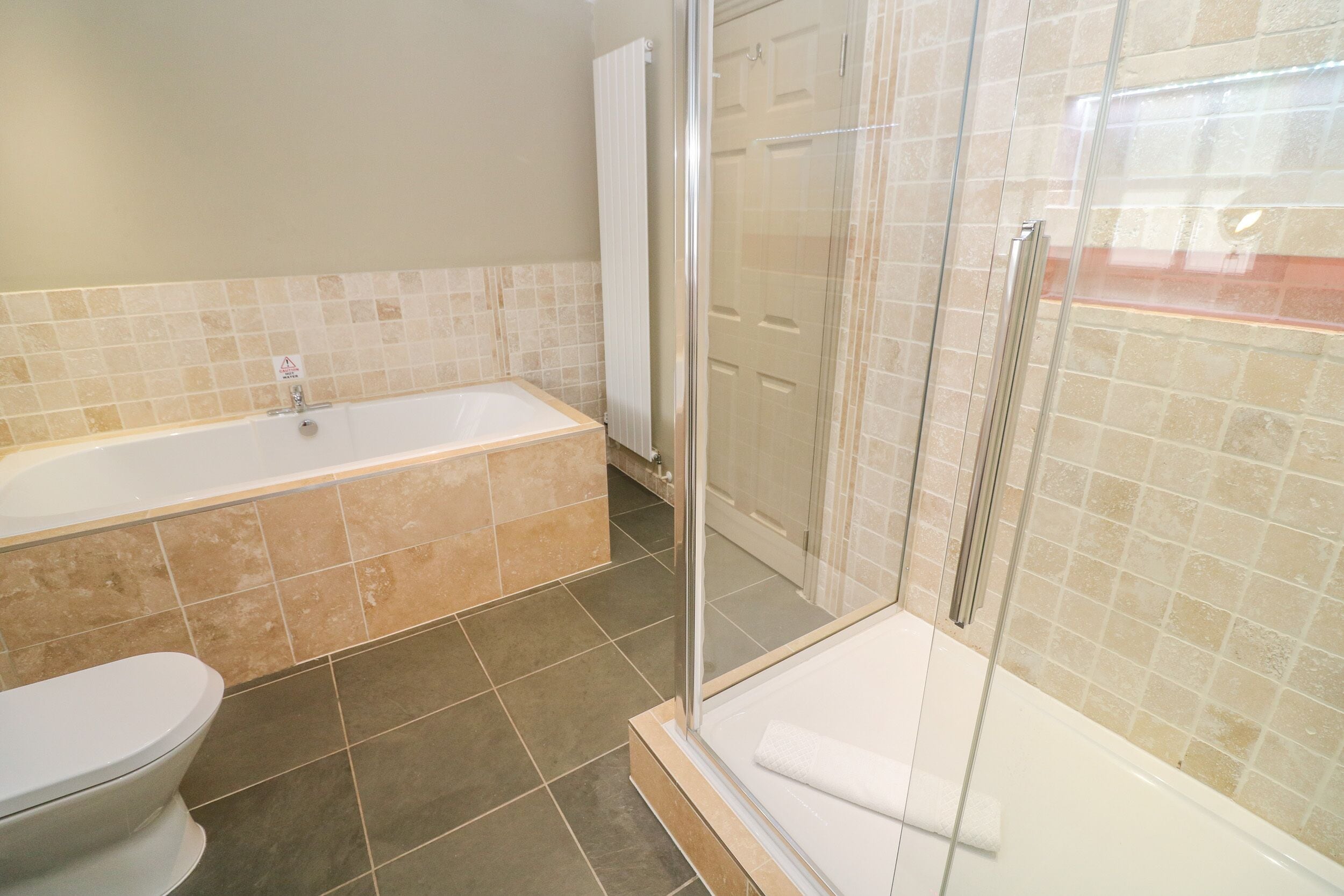 Een badkamer met een bad, toilet en douchecabine.