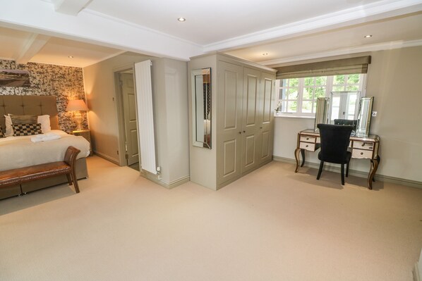 A bedroom with a bed, a desk with a chair, a mirror, and a wardrobe. - Bodmin Country House (Bodmin)