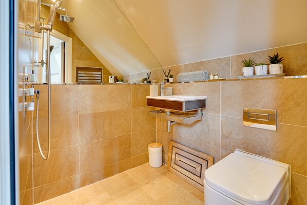 A modern bathroom with a shower, toilet, and vanity.