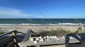 A wooden deck with a collection of seashells and a person sitting on the beach. - Beachfront House with Beautiful Ocean Views and Private Beach Access (Melbourne Beach)