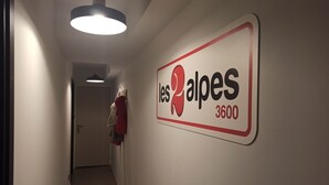 A hallway with a sign reading "les Alpes 3600" on the wall.