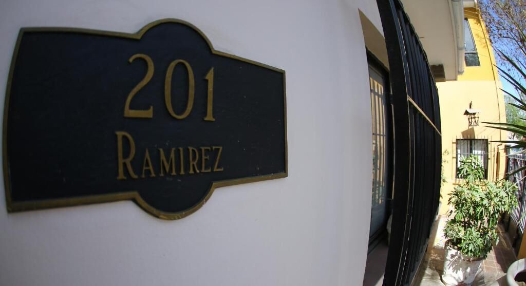 Una placa con el número '201 Ramirez' en una pared blanca.