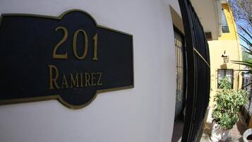 Una placa con el número '201 Ramirez' en una pared blanca.