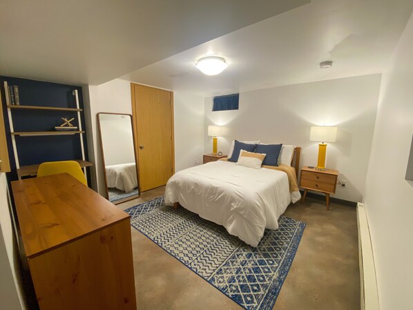A bedroom with a bed, bedside tables, a desk, a chair, a wardrobe, and a mirror. - Apartment close to downtown Rochester, walking distance to Mayo! (Rochester)