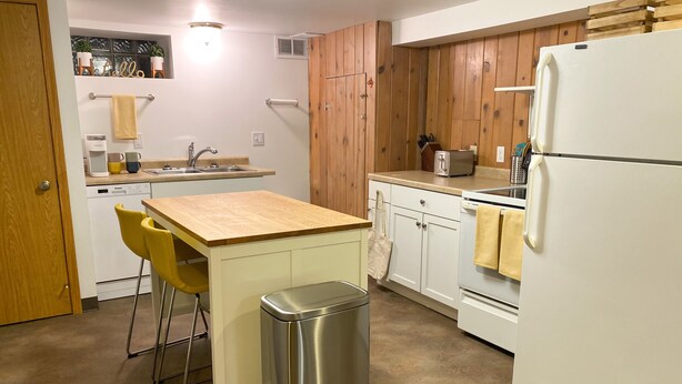 A compact kitchen with a wooden countertop, a sink, a refrigerator, and a trash bin. - Apartment close to downtown Rochester, walking distance to Mayo! (Rochester)