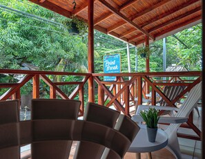 A wooden deck with chairs and tables, surrounded by lush greenery. A sign indicates a 'Point Break' location.