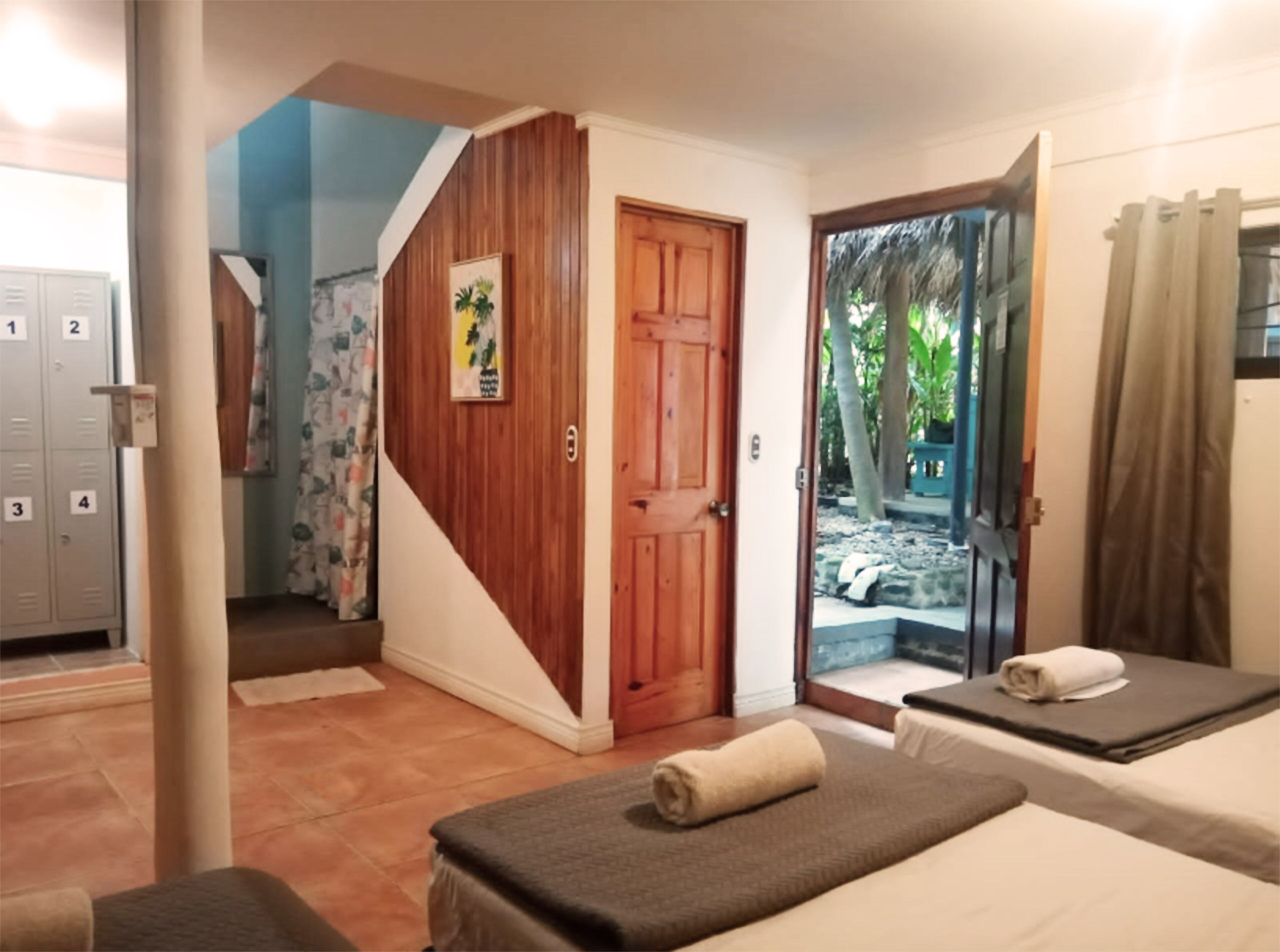 Quarto com cama, mesa de massagem e área de chuveiro.