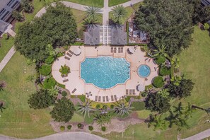 An aerial view of a resort with a central swimming pool, surrounded by palm trees and lounge areas. - 7661 Amazing Condo 3bd/2bth Next to Golf Club (Kissimmee)
