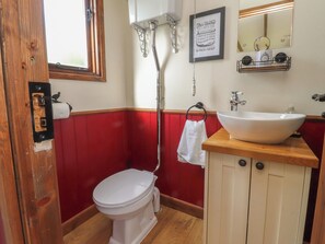 Un bagno con un WC, un lavandino, una doccia e uno specchio.