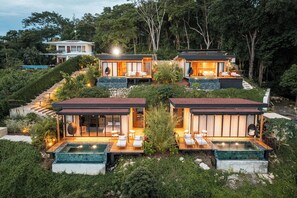 A modern resort with multiple guest villas, each featuring a private outdoor seating area and a hot tub.