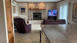 A spacious living area with a large kitchen island, a fireplace, and a television. - Clean newly updated 4 bedroom in quiet Granger (Granger)