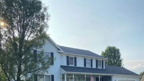 A two-story house with a front porch, a garage, and a well-maintained lawn. - Clean newly updated 4 bedroom in quiet Granger (Granger)
