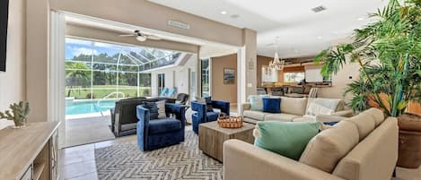 A spacious living area with a pool view, a dining area, and a kitchen.