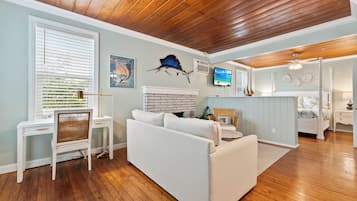 A living room with a white sofa, a television, and a fireplace.