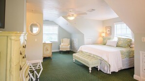 A bedroom with a bed, a chair, a dresser, and a window. - ENCHANTED COTTAGE AT OLD COLORADO INN (Stuart)
