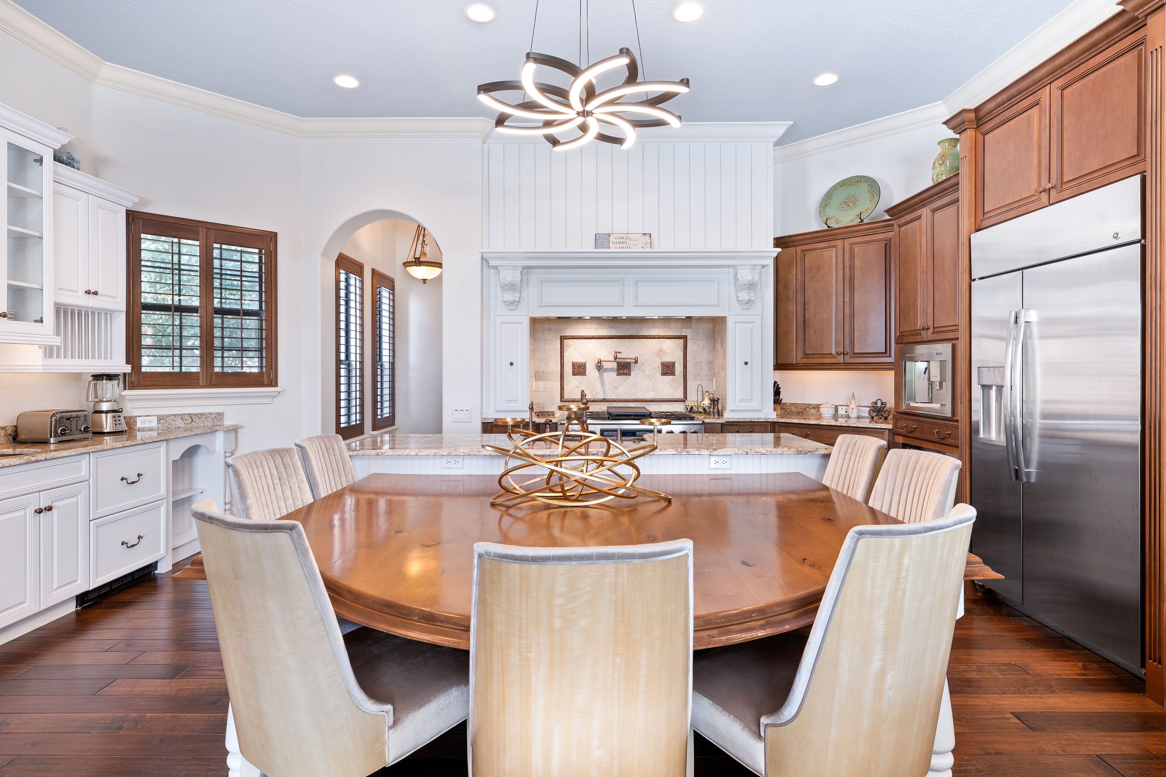 A spacious kitchen with a large island, wooden cabinets, and stainless steel appliances.