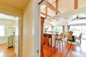 A spacious kitchen with wooden beams, a dining area with wicker chairs, and a view through large windows. - LANGFORD SUITE AT OLD COLORADO INN (Stuart)