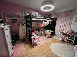 A cozy room with a bunk bed, a dresser, a desk, and various toys and decorations. - Private home, close to Gruene and Rivers! (New Braunfels)