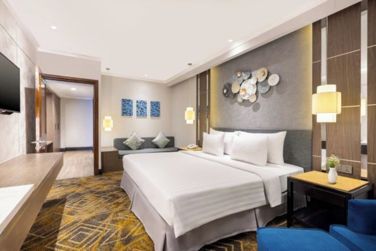 Une chambre d’hôtel avec un grand lit, un bureau et une télévision.