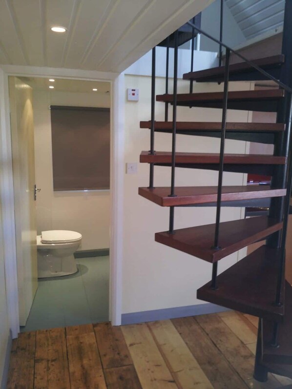 A staircase with wooden steps and metal railings leading to an upper floor. - Heatherbell Accommodation (Bridport)