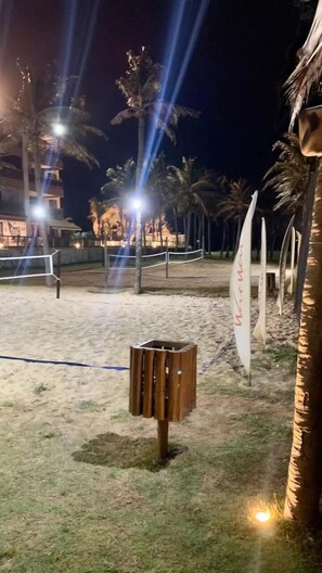 Enjoy a tranquil beachside setting with palm trees and a nearby building.