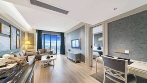 A modern hotel room with a marble bar, a sofa set, a desk, and a large window offering a city view. - Howard Johnson by Wyndham Lake Serenity Hot Springs Xichang (Liangshan Yi)