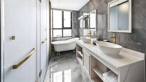 A modern bathroom with a freestanding bathtub, a large mirror, and a vanity with a vessel sink. - Howard Johnson by Wyndham Lake Serenity Hot Springs Xichang (Liangshan Yi)
