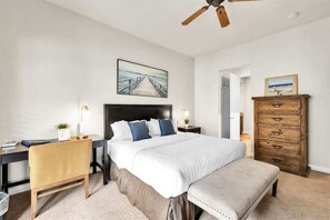A bedroom with a bed, bedside tables, a dresser, a chair, and a ceiling fan. - Desert Sky Vista B | Studio Legacy Villa (La Quinta)