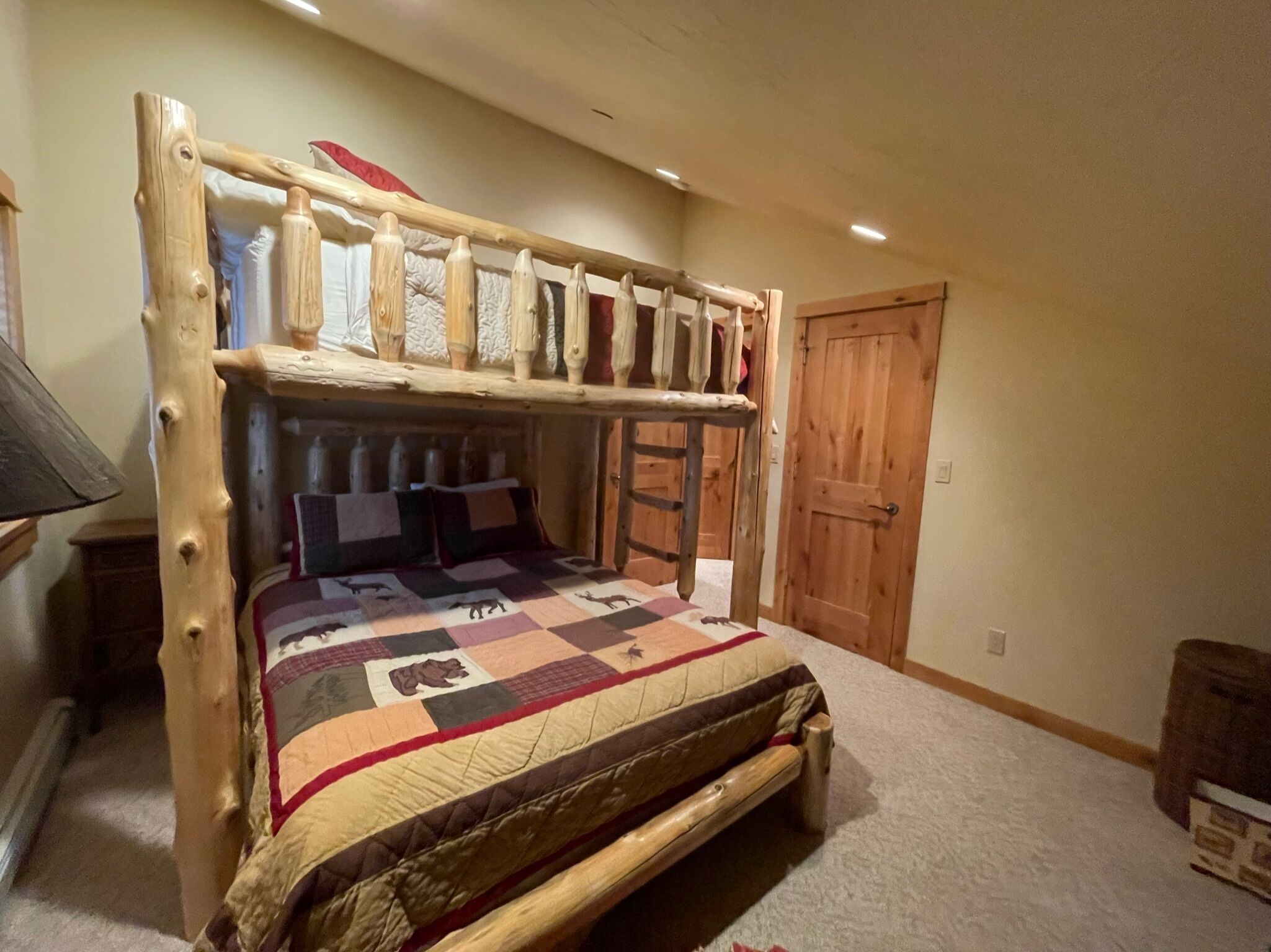 Een stapelbed met een houten frame en een gewatteerde sprei.