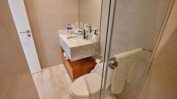 A modern bathroom with a toilet, sink, and shower.