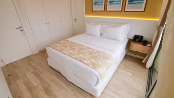 Habitación de hotel con una cama grande, una mesita de noche con teléfono y una lámpara de pared.