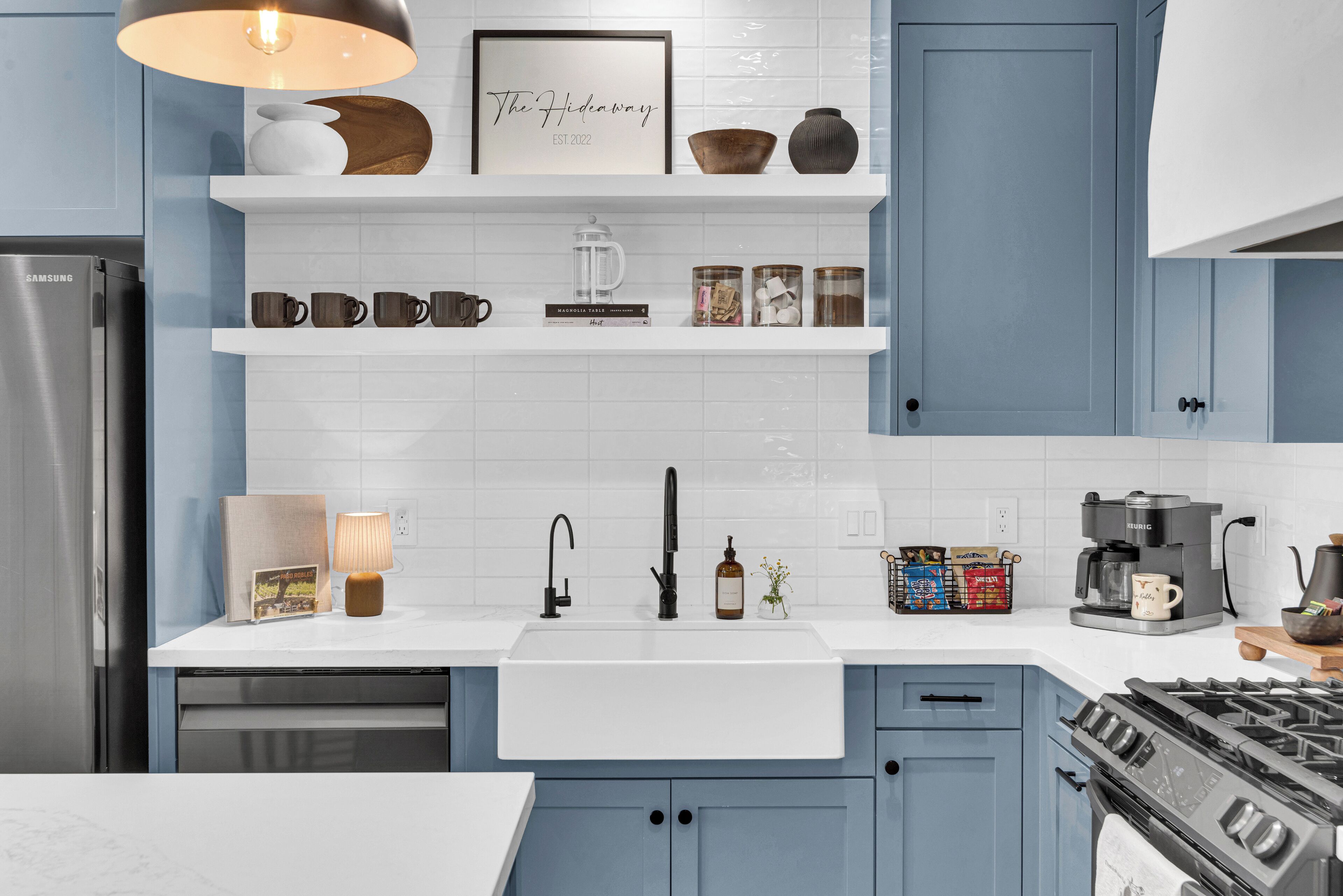A modern kitchen with a stainless steel refrigerator, a built-in oven, and a gas stove.